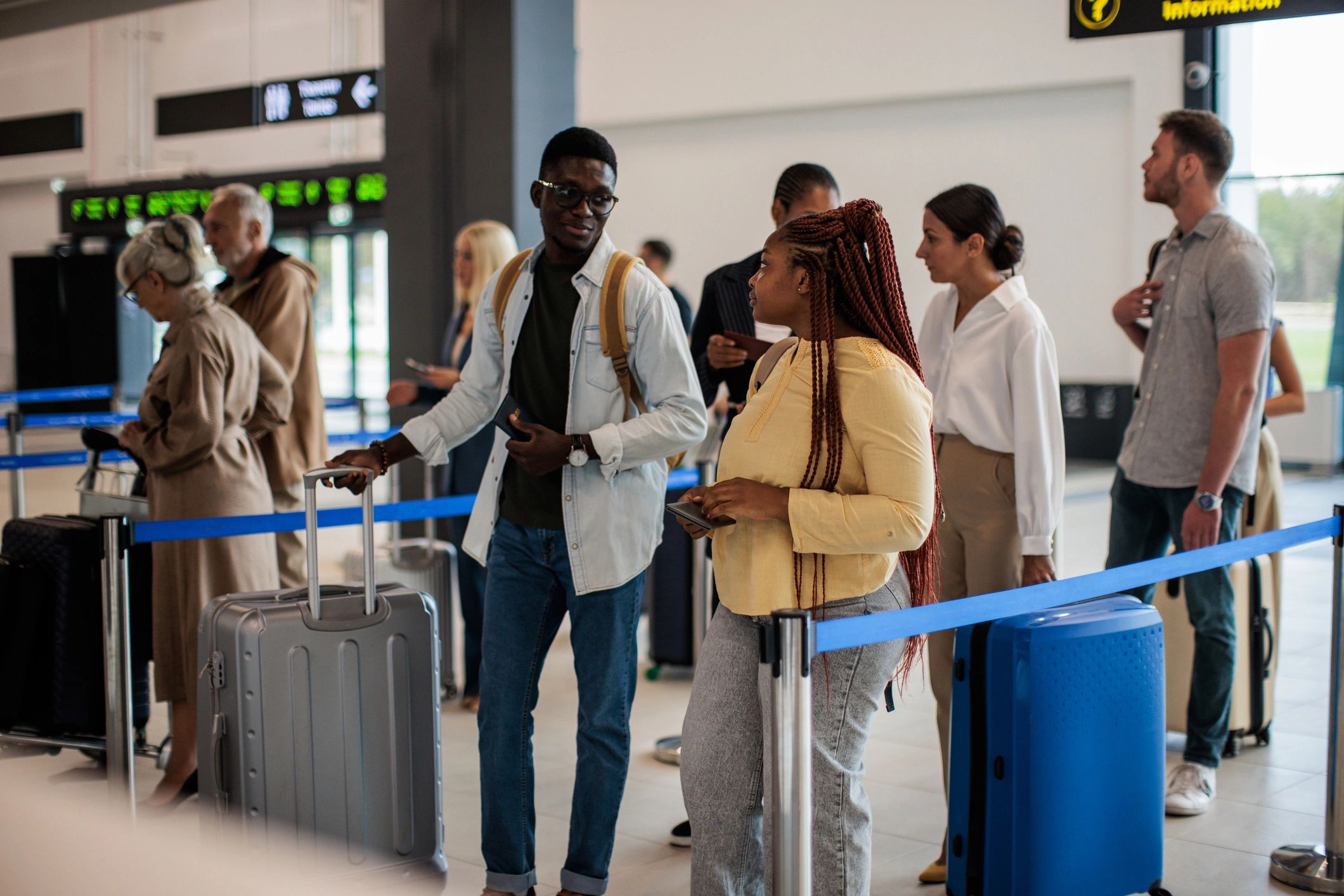 Travelers in an airport terminal talking near check-in area