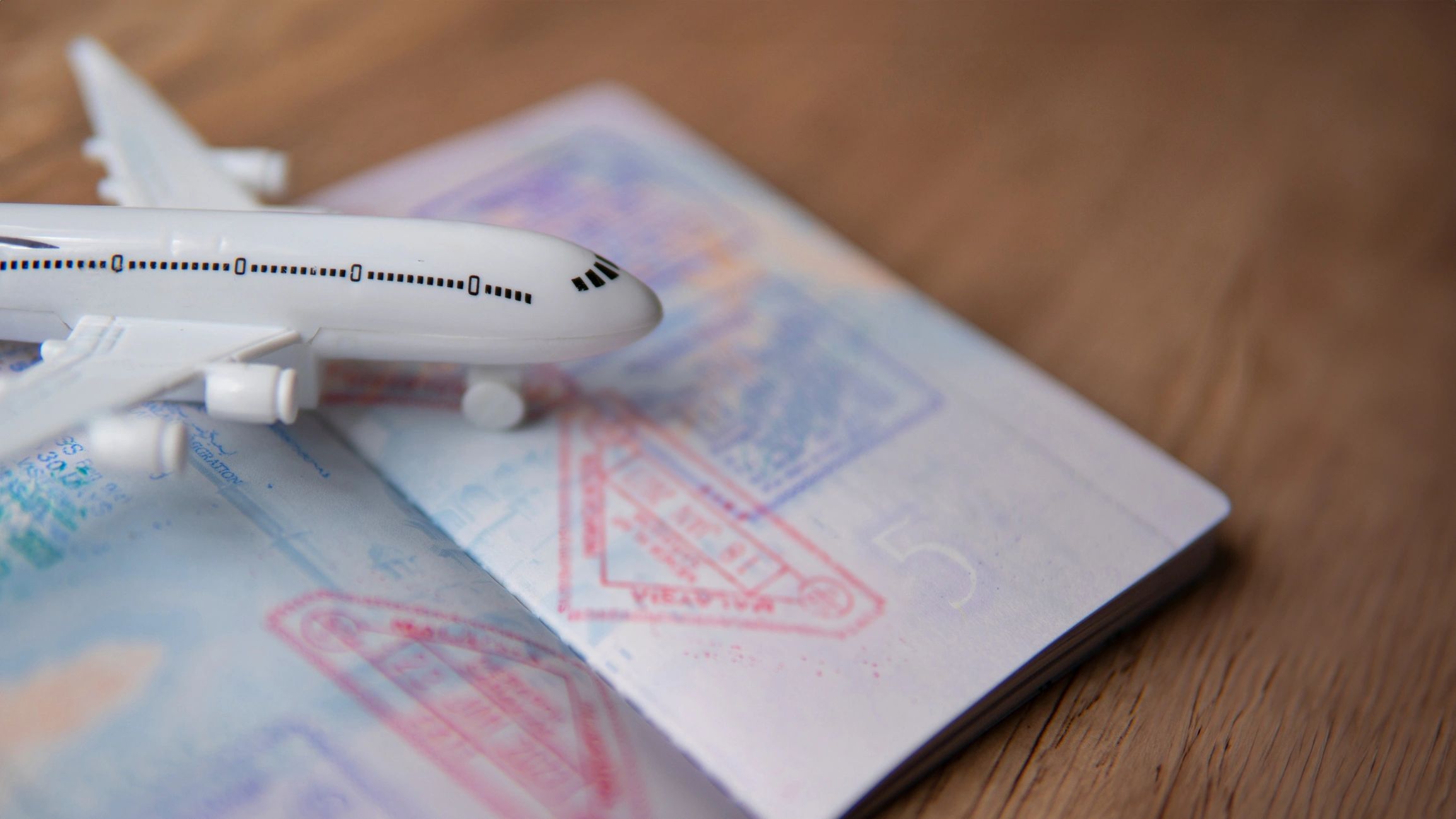 Model airplane on an open passport with stamps