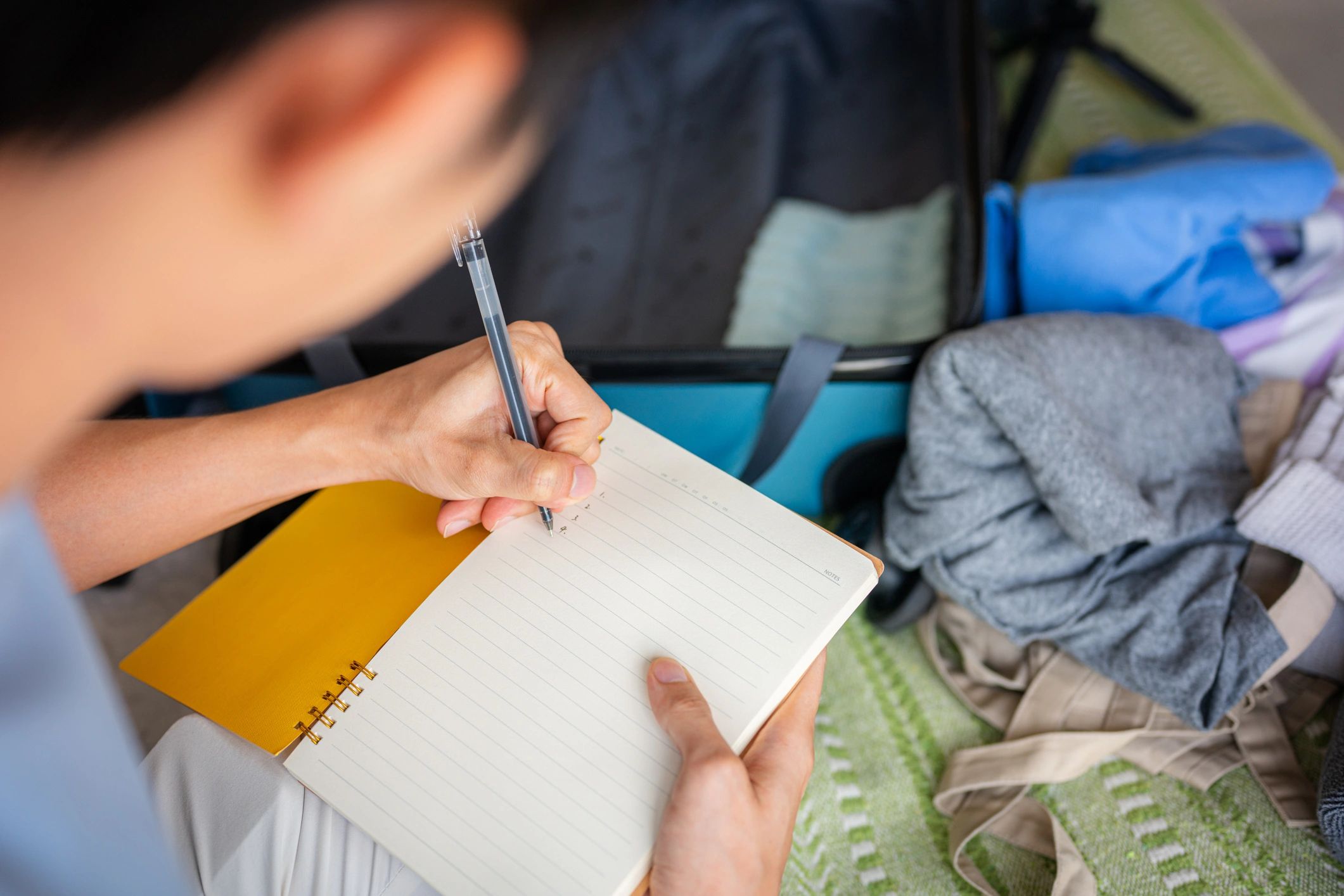 Portrait of a traveler packing and writing notes