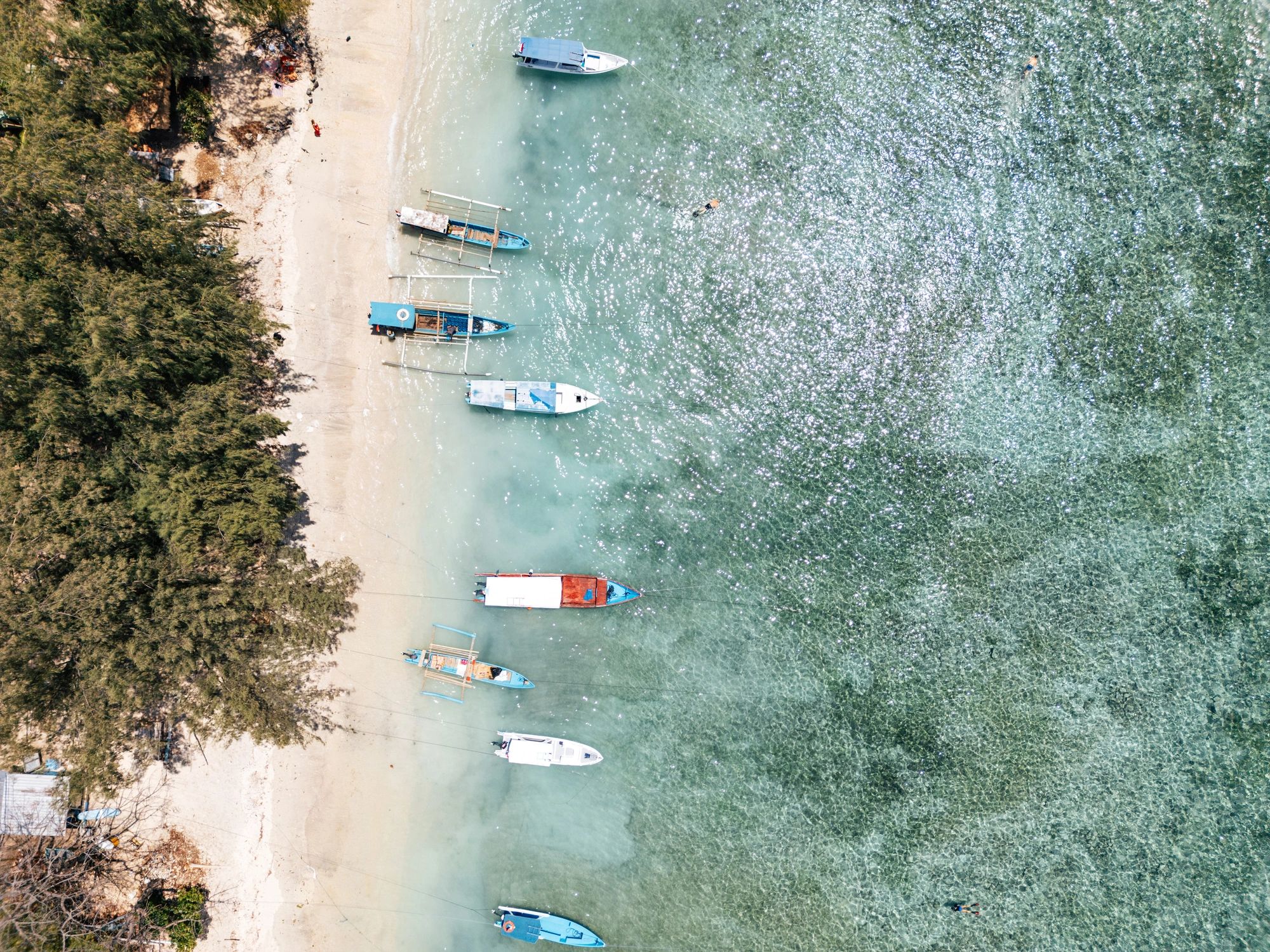 Tropical beach with boats and clear blue water